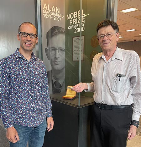 Professor Joel Miller (right) presenting MacDiarmid Institute Professor Justin Hodgkiss with the piece of conducting polymer for which Alan MacDiarmid's Nobel Prize was awarded